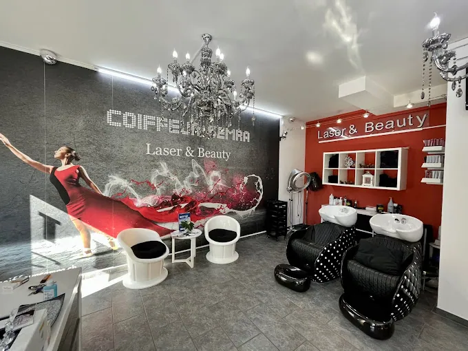Salon von Coiffeur Semra: Wandbild mit einer Frau im roten Kleid, rote Wand mit Regalen, weisse Stühle und schwarze Waschplätze
